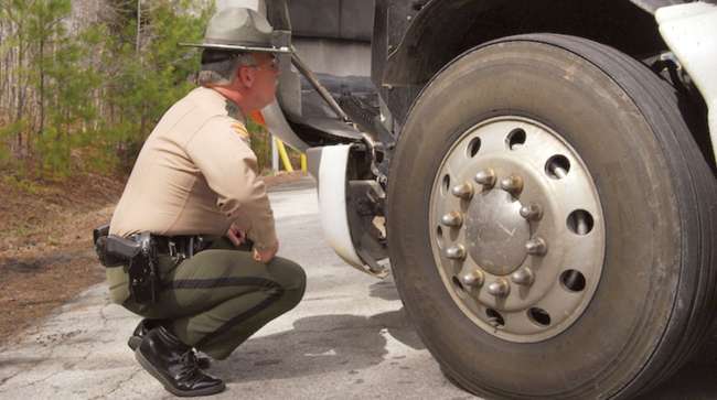 An officer performs a roadside inspection