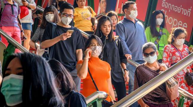 People with face masks arrive at a train station in Bangkok on Jan. 27.