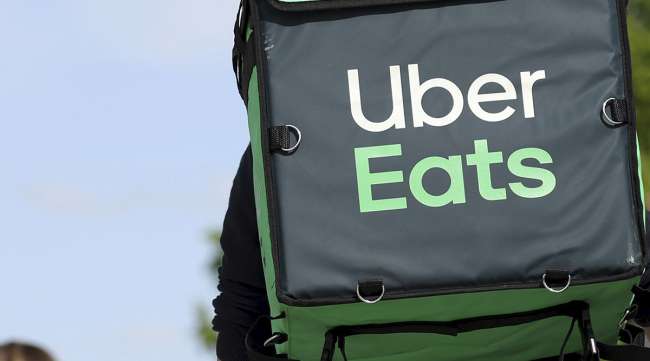An Uber Eats delivery cyclist carries a thermal insulated food backpack