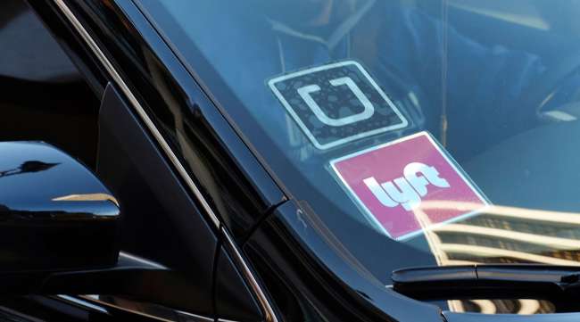 A rideshare car displays Lyft and Uber stickers in downtown Los Angeles. (Richard Vogel/Associated Press)