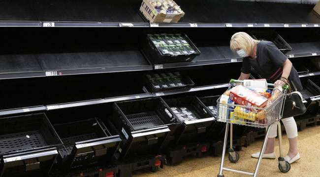 A woman wearing a face mask near empty fruit and veg shelves in Cardiff, Wales