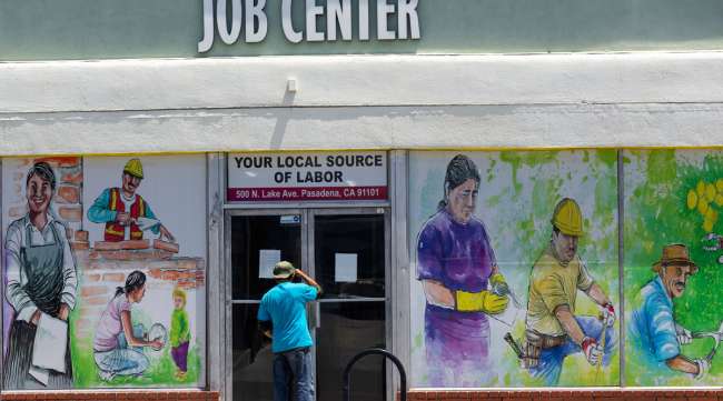 A person looks inside the closed doors of a job center in California on May 7.