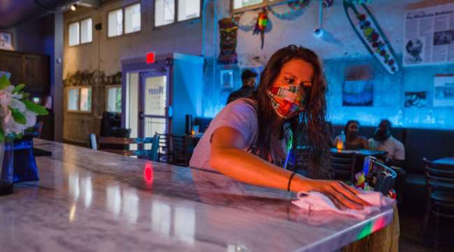 A worker disinfects a bar at a nightclub in South Carolina.