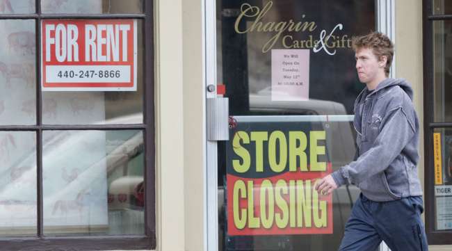 A man walks past a closed business in Chagrin Falls, Ohio, on April 29.