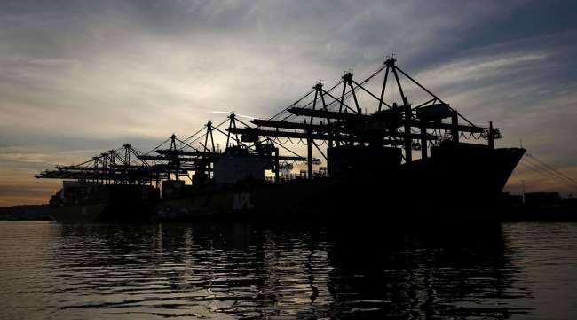 The silhouette of cranes are seen unloading container ships at the Port of Los Angeles in San Pedro, Calif.
