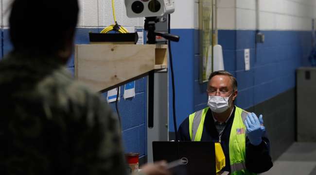 A Ford employee, left, has his temperature checked as he enters a Ford plant in Michigan on May 13.