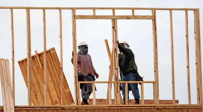 Construction workers build a new home in Houston on June 23.