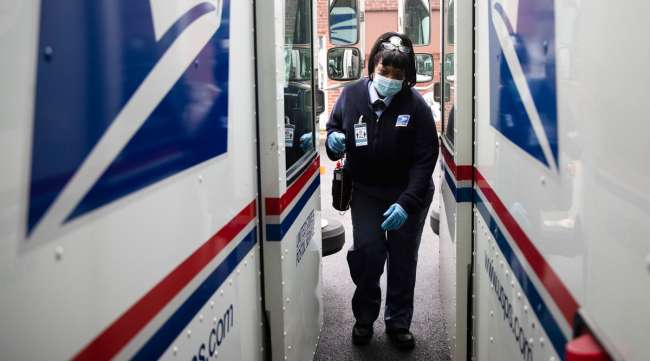 A USPS carrier gets into her truck to deliver mail in Philadelphia in May.