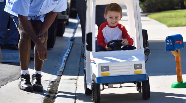 Jacob Hayward, 7, drives a miniature mail truck