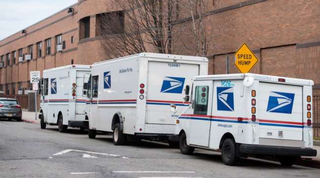 USPS trucks sit parked behind a post office in New Jersey on in January.