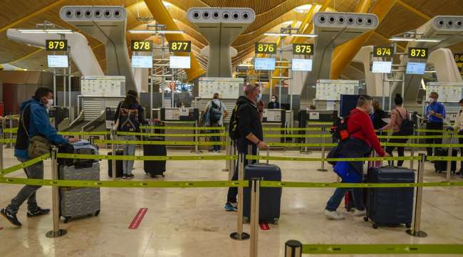 Passengers queue according to social distancing measures at the Madrid Barajas airport in Spain on May 20.