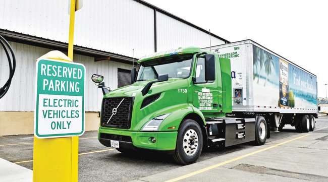 A Volvo VNR Electric truck at a charging station.