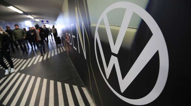 Travelers pass a VW advertisement on a railway station subway wall near company headquarters in Wolfsburg, Germany, on March 12.