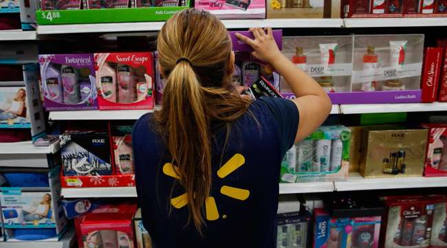A Walmart employee organizes store shelves