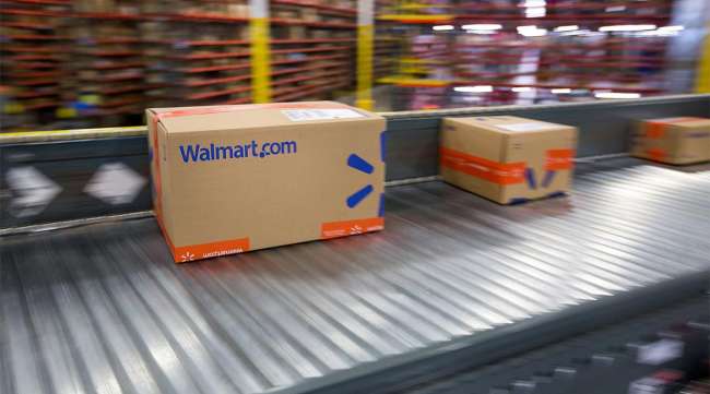 Packages move along a conveyor belt inside a Walmart fulfillment center.