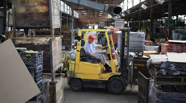 A worker drives a forklift inside a shipping warehouse at the Fiesta Tableware Co. factory in Newell, W.Va.