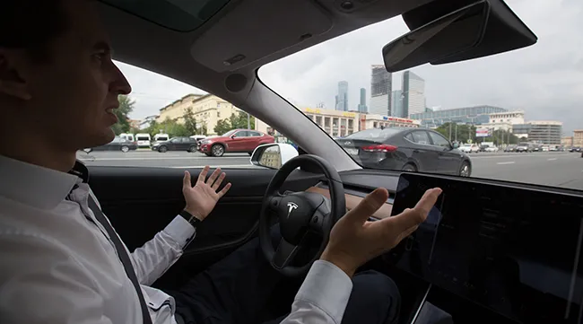Igor Antarov demonstrates the autonomous driving feature of a Tesla Model 3