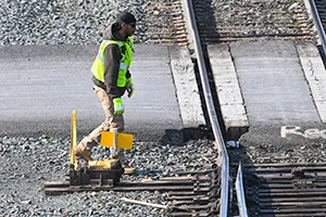 A rail worker switches a track for a locomotive