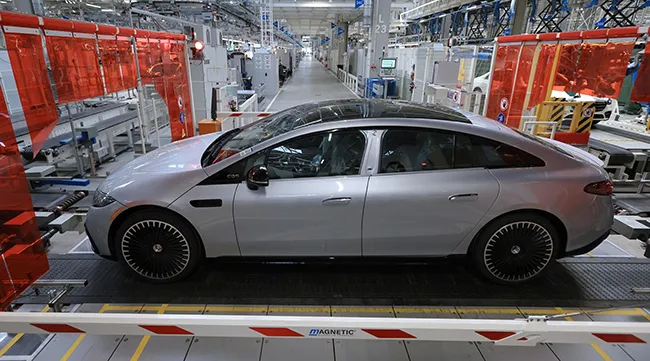 A Mercedes-Benz EQS electric vehicle on the assembly line
