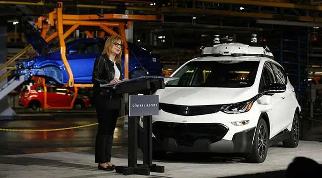GM CEO Mary Barra next to a self-driving Chevy Bol