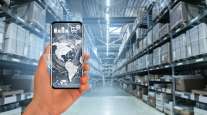 Getty Image of a hand holding a cellphone in a warehouse