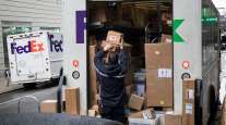 An independent contractor to FedEx Corp. unloads packages