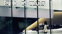 A Nissan showroom employee cleans a car