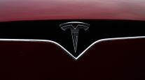A logo is displayed on a Tesla Inc. vehicle