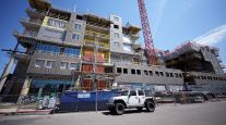 A crane stands over a residential construction project in downtown Denver