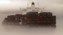 A cargo ship clouded in fog