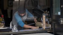 A worker cleans a plexiglass shield at a pizza restaurant in San Francisco. (David Paul Morris/Bloomberg News)