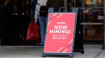 A hiring sign is displayed outside of a retail store in Vernon Hills, Ill.