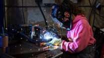 A worker welds bumpers at a facility in Eugene, Ore. (Alisha Jucevic/Bloomberg News)