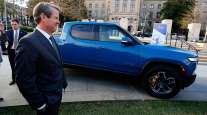 Gov. Brian Kemp stands next to a Rivian electric truck