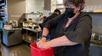 Folsom Vice Mayor Sarah Aquino wrings out a rag before cleaning a table at Back Bistro in Folsom, Calif.