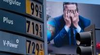 Gas prices are seen in front of a billboard advertising HBO's Last Week Tonight in Los Angeles, March 7