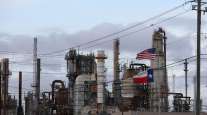 American and Texas flags stand in front of the Chevron Pasadena Refinery in Texas. (Sharon Steinmann/Bloomberg News)