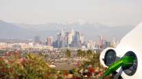 Getty Image of electric vehicle charging with Los Angeles as a backdrop