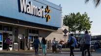Shoppers walk in front of a Walmart store in San Leandro, Calif.