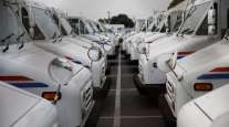 U.S. Postal Service delivery vehicles sit outside a post office in California. (Patrick T. Fallon/Bloomberg News)
