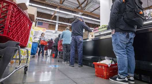 Shoppers wait in line to checkout inside a grocery store in San Francisco