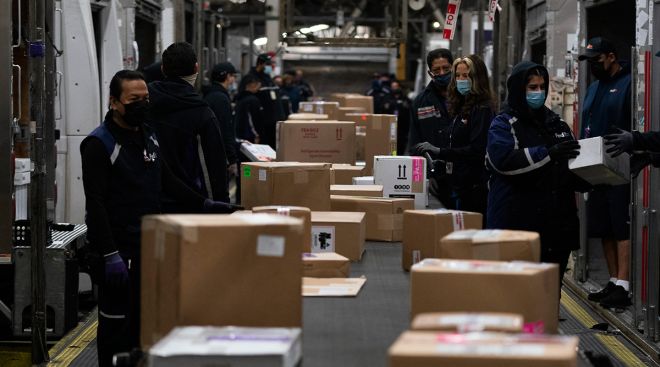 Employees sort packages for delivery at the FedEx regional hub