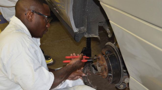 A Windham School District student works on brakes
