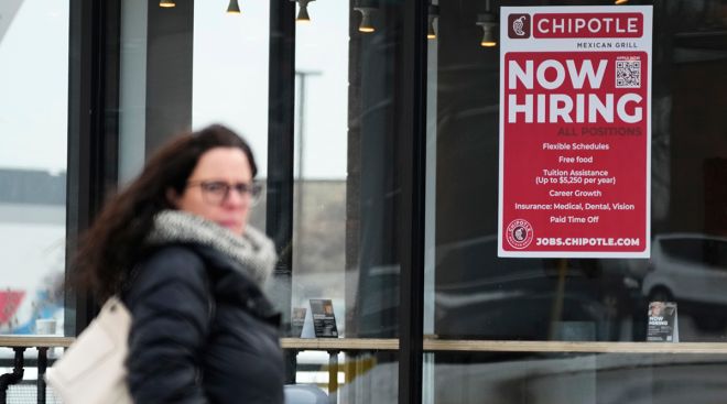 A hiring sign is displayed at a Chipotle restaurant