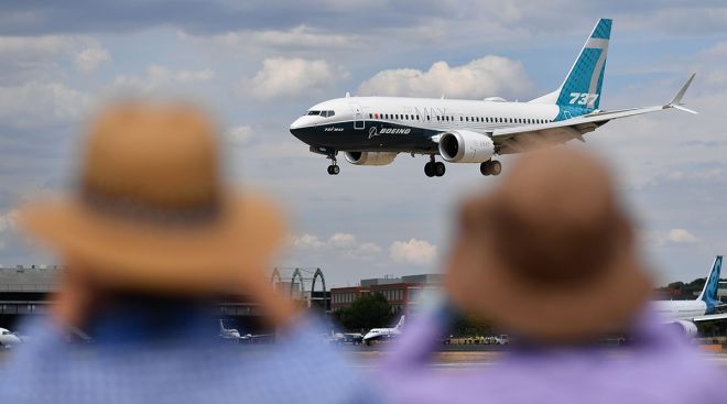 People watch a Boeing 737 land