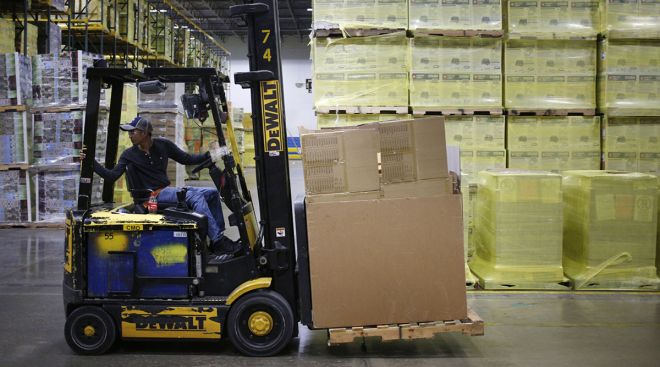 A warehouse worker operates a forklift