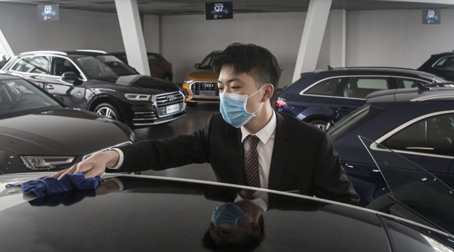 An employee wipes a vehicle on display inside an Audi AG dealership in Wuhan, China, on April 6.